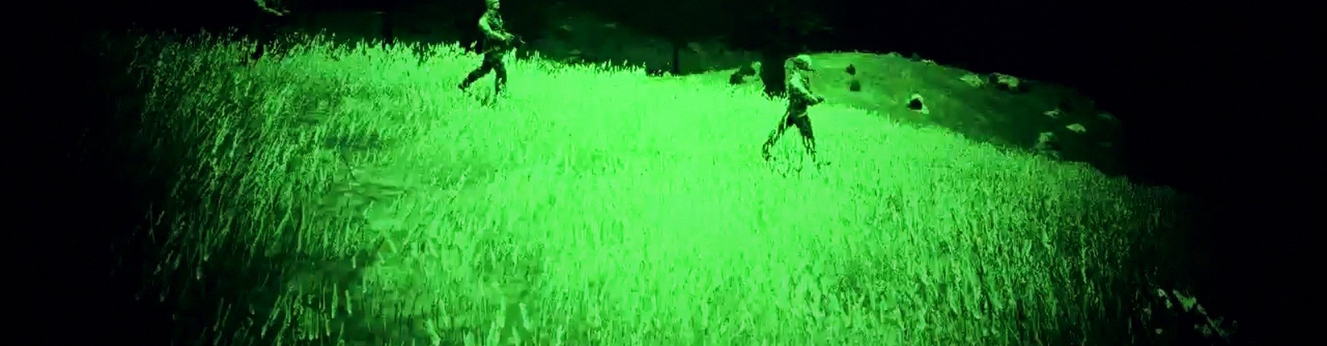 Soldiers crossing a field through night vision goggles