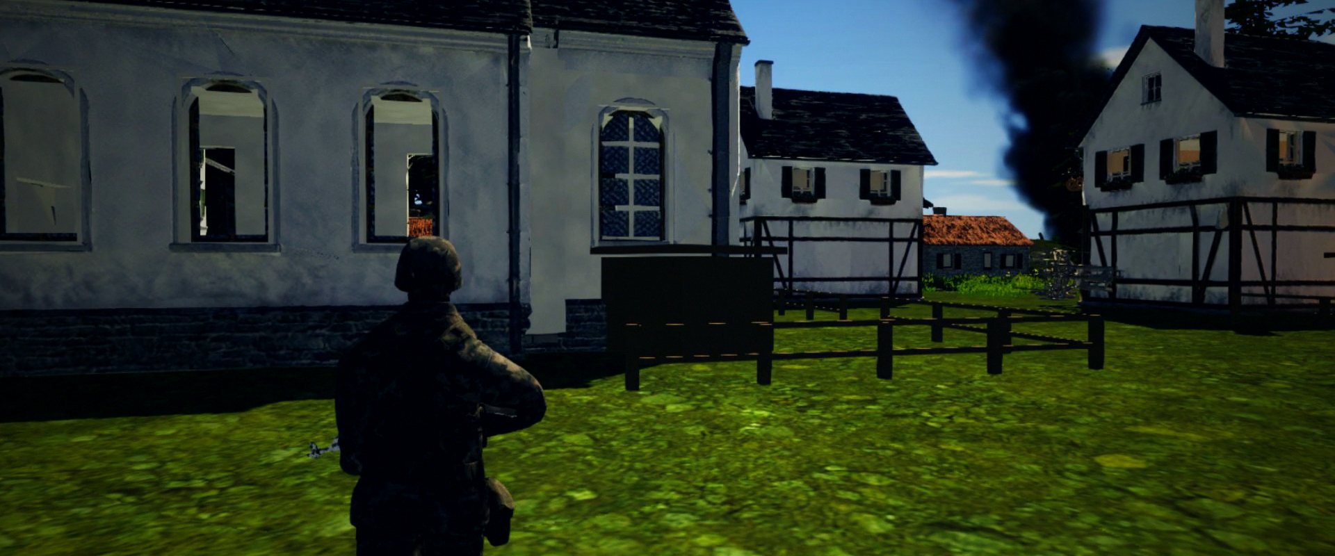 A soldier watching smoke rise behind a town